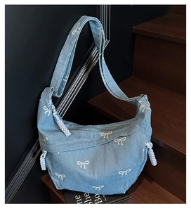 Detailansicht der hellblauen Denim-Tasche mit weißen Schleifenmustern und gewebtem Seilzug
