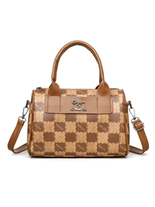 Macro view of checkered canvas bag material with leather texture and brand logo detail