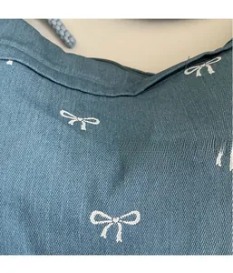 Nahaufnahme der blauen Denim-Stoffstruktur mit weißen Schleifenprints für Schultertasche