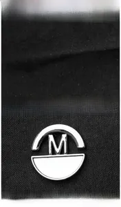Detailed macro view of black oxford fabric texture and silver M Fashion hardware on a backpack