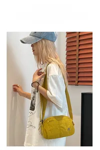 Detail view of the bright yellow puff crossbody bag with multi-layer zipper compartments