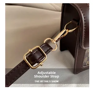 Detailed view of adjustable shoulder strap with gold-tone buckle on vintage crossbody bag