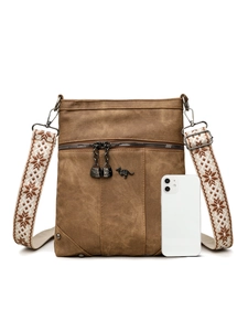 Close-up of brown canvas crossbody bag with decorative strap and smartphone for scale