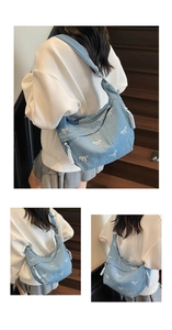 Detail der hellblauen Jeans-Umhängetasche mit weißem Schleifendruck und Kordel-Zipper
