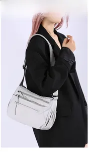 Detailed side view of multi-pocket nylon crossbody bag with adjustable strap and light gray finish