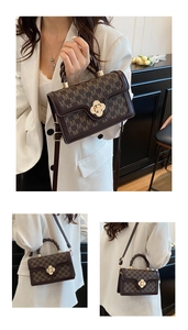 Detail of vintage brown crossbody bag with M-pattern and gold clover clasp