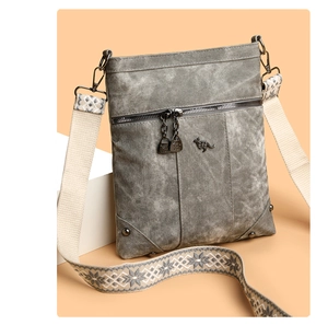 Detail of grey washed canvas crossbody bag with kangaroo logo and geometric strap