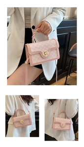 Close-up of pink monogram crossbody bag with floral gold clasp and woven handle