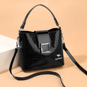 Black crocodile pattern bucket bag with silver buckle and adjustable strap in side view