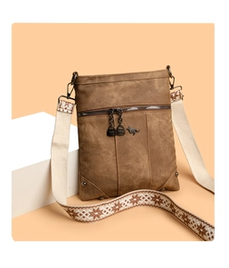 Detail of coffee canvas crossbody bag featuring kangaroo logo and ethnic patterned strap