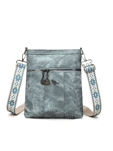 Detail of kangaroo logo on blue PU leather crossbody bag with ethnic jacquard strap