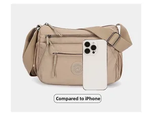 Size comparison of beige multi-pocket oxford crossbody bag shown next to an iPhone