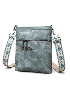 Close-up of vintage blue PU leather bag featuring snowflake jacquard strap and metal charm