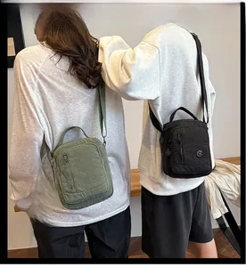 Rear view of models showcasing nylon crossbody bags in olive green and black colors
