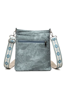 Detail view of the gray-blue crossbody bag featuring an ethnic style star pattern strap