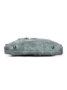 Detail view of washed denim bag base featuring four anti-wear protective metal studs