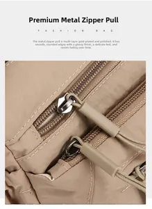 Detail of durable gold-plated metal zippers on a khaki canvas multi-layer shoulder bag