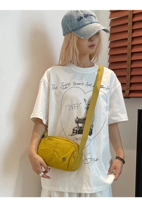 Detail of yellow lightweight crossbody bag with wrinkled texture and adjustable strap