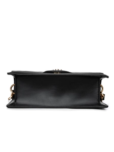 Detail view of the black crossbody bag bottom with premium texture and gold rings