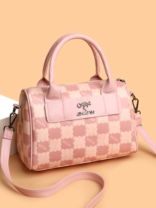 Detail of pink plaid Boston bag featuring metal kangaroo pendant and detachable strap