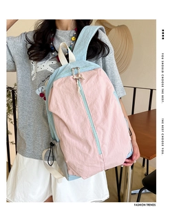 Detailed view of the pink and blue patchwork waterproof yoga backpack worn by a model