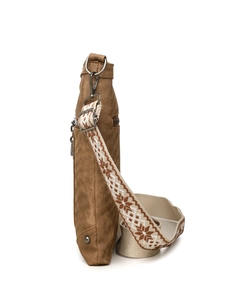 Detail view of ethnic embroidery strap and metal hardware on brown canvas crossbody bag