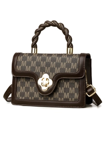 Detail of vintage crossbody bag with M-pattern leather, rope handle and gold petal clasp