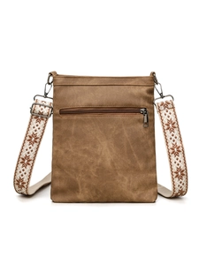 Detail of brown canvas crossbody bag with bohemian woven strap and metal zipper pocket