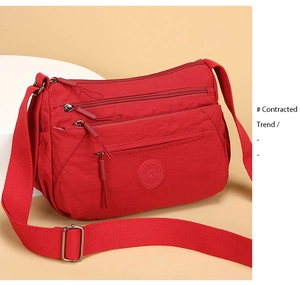 Close-up of red multi-pocket oxford crossbody bag with adjustable wide shoulder strap