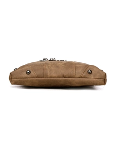 Detailed base view of brown crossbody bag showing woven texture and protective metal studs