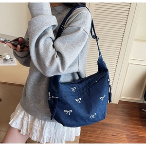 Detailansicht der dunkelblauen Denim Hobo Bag mit weißen Schleifenstickereien