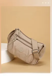 Detail of waterproof nylon crossbody bag with multi-layer zippers and adjustable strap