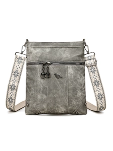 Detail view of smoky grey crossbody bag featuring metallic kangaroo logo and woven strap