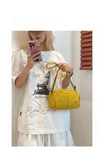 Detail of yellow lightweight nylon puffy crossbody bag with adjustable strap and side pocket