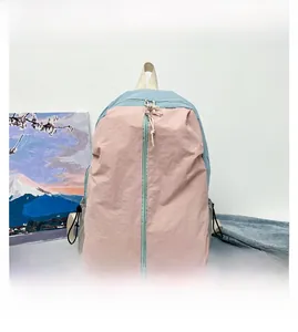 Detailed view of pink and light blue nylon yoga bag with side drawstring bottle pocket