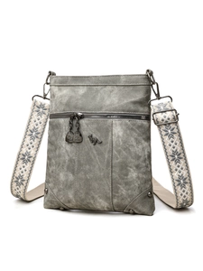 Close-up of grey PU crossbody bag with kangaroo metal logo and patterned wide strap
