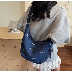 Detailansicht der großen blauen Denim-Umhängetasche mit weißen Schleifenmustern