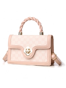 Detail of pink crossbody bag featuring monogram canvas and gold flower clasp