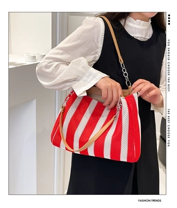 Detail of red and white striped woven tote with brown leather strap and chain