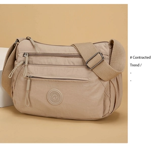 Detailed view of beige Oxford fabric crossbody bag with multi-layer zipper pockets