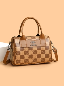 Close-up of brown checkered tote with gold kangaroo logo and adjustable leather strap