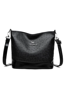 Detail of black ostrich embossed texture with silver kangaroo logo on crossbody bag
