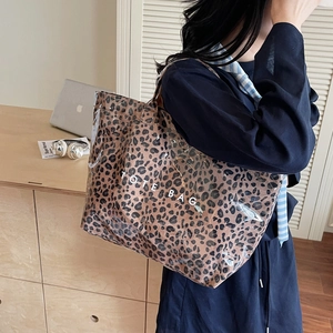 Fashionable leopard print PVC tote bag with canvas interior and white TOTE BAG text print