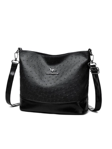 Detail of ostrich texture faux leather bag with silver kangaroo logo and adjustable strap