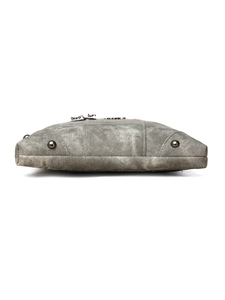Detailed base view of washed denim crossbody bag featuring protective metal bottom studs