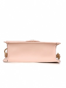 Detailed back view of pink rectangular handbag with elegant gold ring hardware details