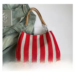 Detail of red and white striped knit tote bag with silver chain links and leather strap