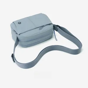 Macro view of light blue puffer crossbody bag featuring multiple zipper pockets and fabric strap