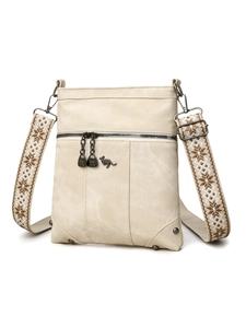 Detail of beige canvas crossbody bag featuring jacquard strap and metallic kangaroo logo