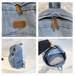 Detail view of denim backpack showing leather logo, zipper, and spacious inner storage